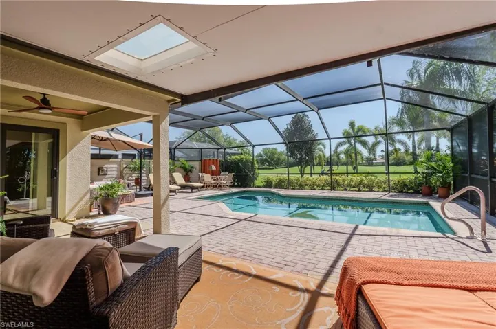 Swimming pool with a patio, a sunroom, and glass enclosure