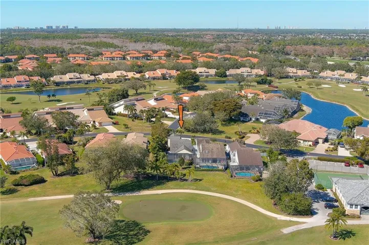 View of property location with a golf course, a nearby body of water, and nearby suburban area