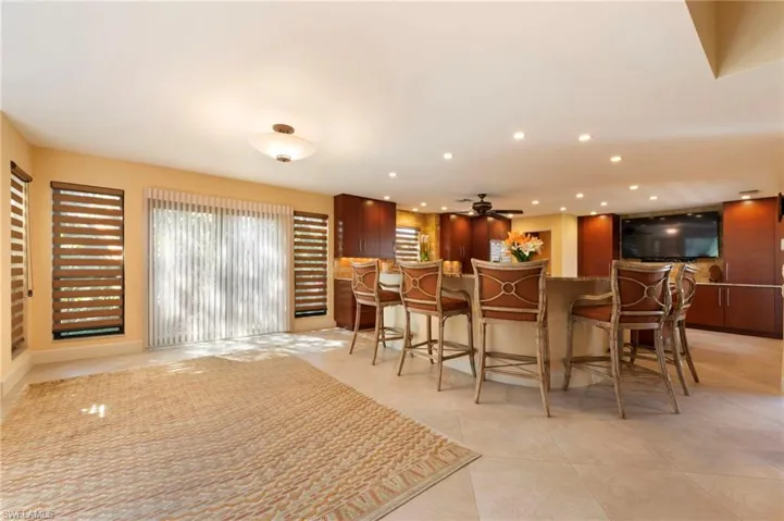 Bar area with recessed lighting, a ceiling fan, and light stone counters