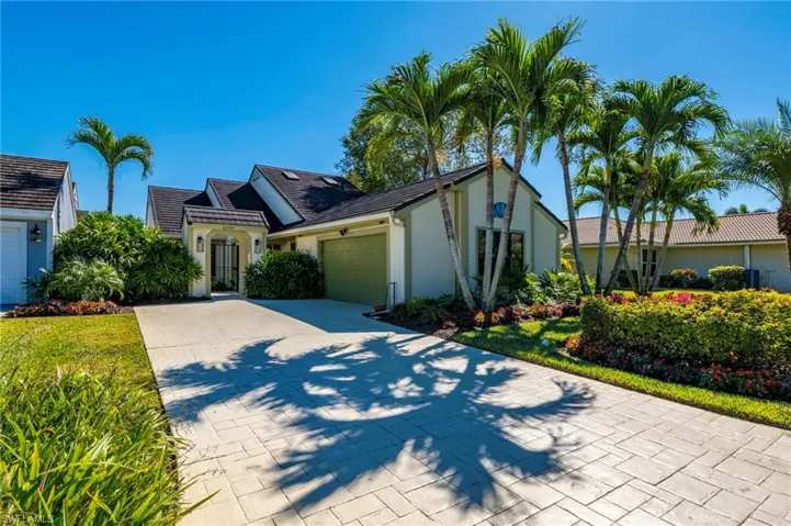 View of front of property with an attached garage, driveway, and stucco siding
