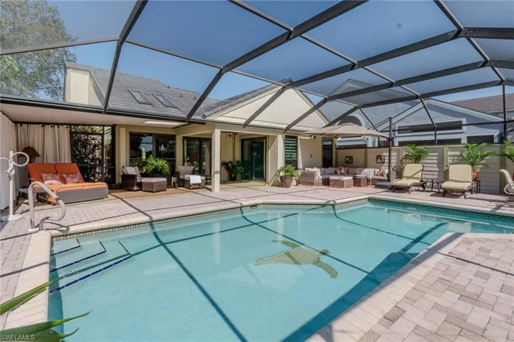 View of swimming pool with outdoor furniture, a sunroom, patio surround, and glass enclosure