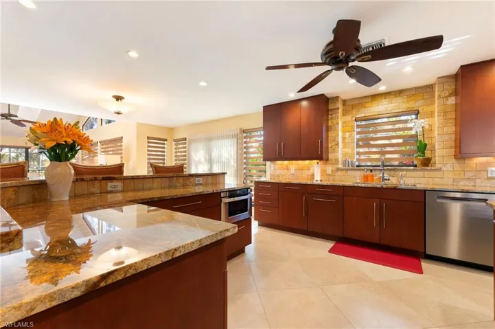 Kitchen with ceiling fan, stainless steel appliances, light stone countertops, tasteful backsplash, and recessed lighting