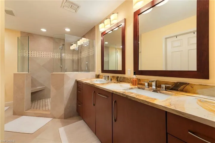 Full bathroom with double vanity, light tile patterned flooring, a walk in shower, and recessed lighting