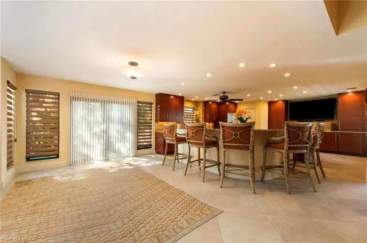 Bar with recessed lighting, light tile patterned floors, ceiling fan, and light stone counters