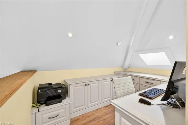 Office space featuring light wood-type flooring, recessed lighting, and a skylight