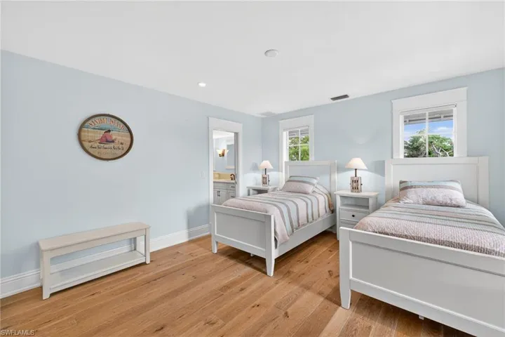 Bedroom with multiple windows, light wood-style floors, and recessed lighting