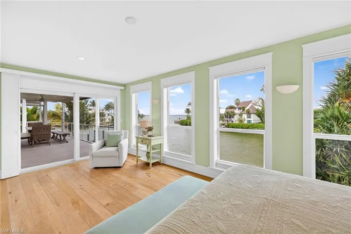 Bedroom featuring access to outside, light wood-style floors, and multiple windows