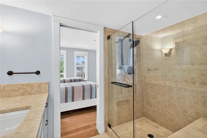 Full bath with vanity, ensuite bath, a shower stall, wood finished floors, and recessed lighting