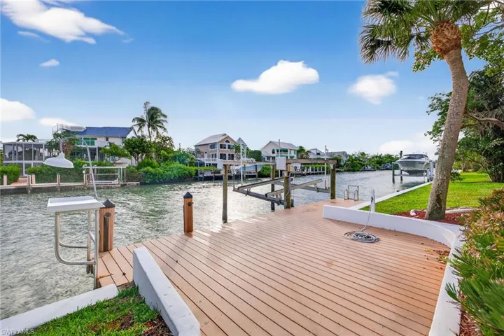 Dock area featuring a water view, a residential view, and boat lift