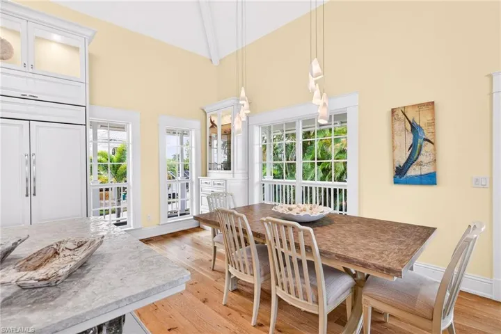 Dining room featuring high vaulted ceiling, light wood-type flooring, and beamed ceiling