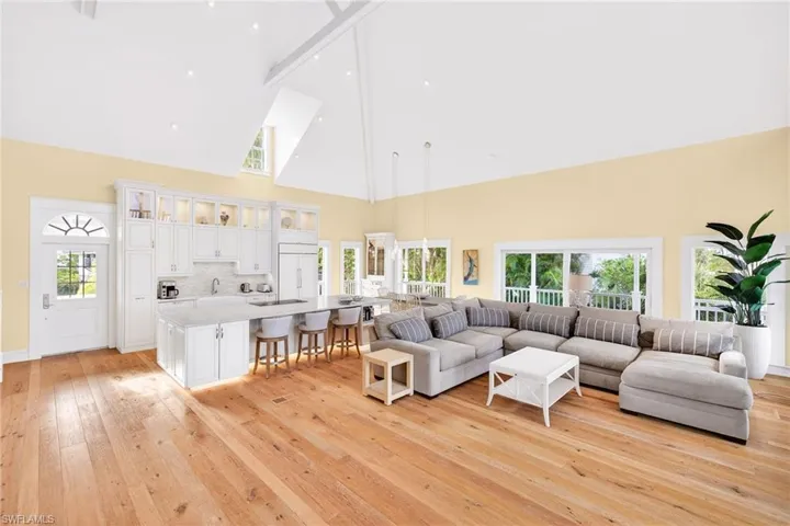 Living area featuring high vaulted ceiling, beam ceiling, and light wood-style floors