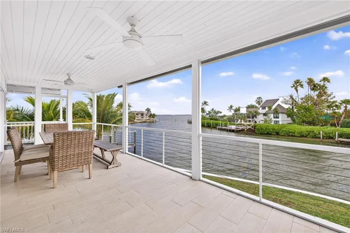Unfurnished sunroom featuring a water view and ceiling fan