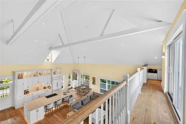 Hall with beam ceiling, plenty of natural light, light wood-style floors, high vaulted ceiling, and recessed lighting