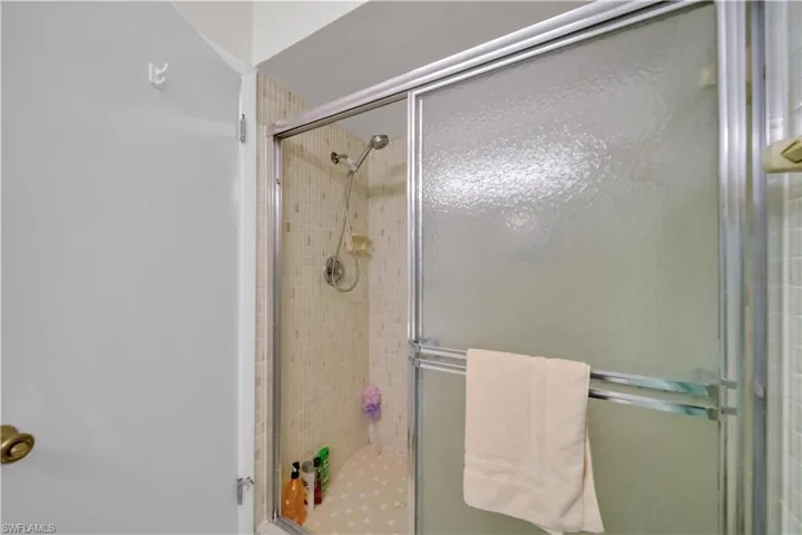 Shower enclosure featuring textured glass sliding doors and a chrome frame