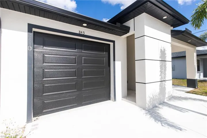Property entrance featuring stucco siding and a garage