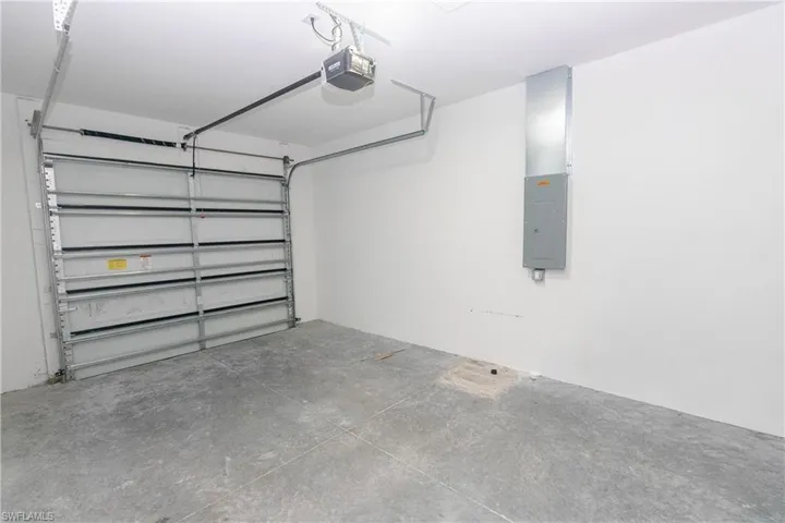 Garage with electric panel and a garage door opener