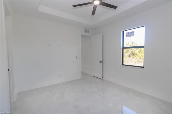 Bedroom featuring a raised ceiling and ceiling fan