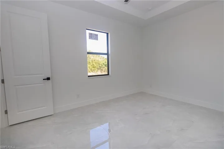 Bedroom featuring baseboards and a tray ceiling