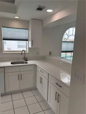 New wood cabinetry and white diamond Quartz countertops and recessed lighting keep the kitchen light and bright