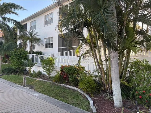 Landscaped exterior view of unit’s screened lanai, one of the  2 community ramps leading to dock area and Tiki deckOne of the most convenient units in the complex!