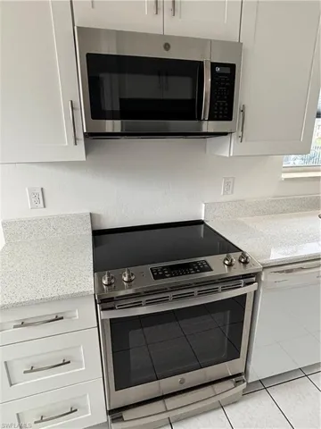 Smooth top range and built in microwave accented with stainless steel lend a sleek and modern look to the kitchen