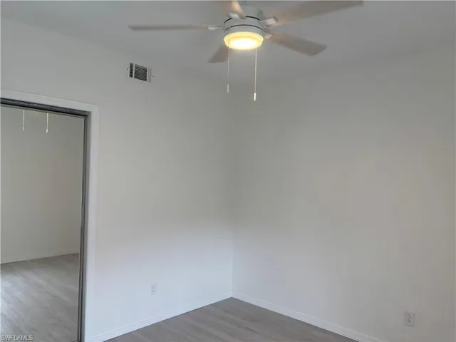 Guest bedroom has LVP flooring and double, mirror door closet