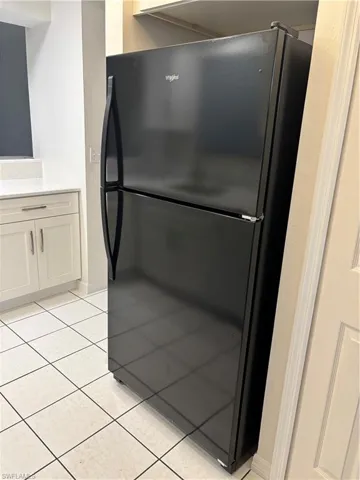 Brand new black Whirlpool refrigerator gives a blended look with the  range and microwave.