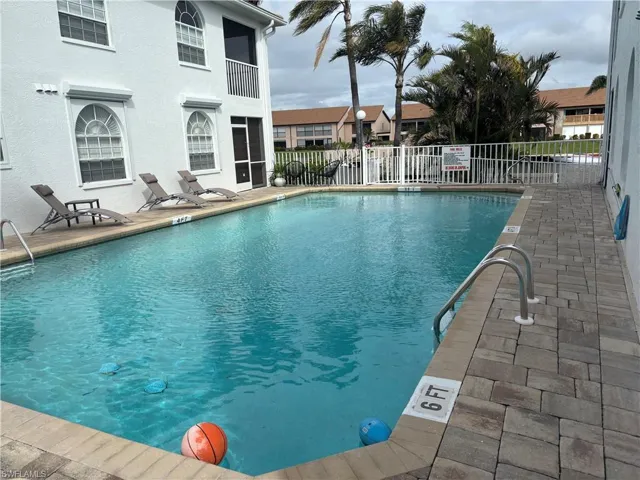 Heated community pool with pavered deck has access from both the front and dock side of the complex