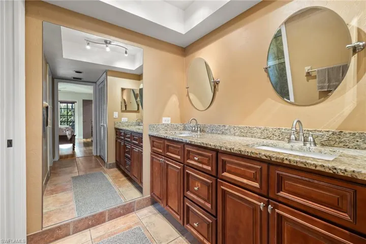 Bathroom featuring tile patterned flooring, vanity, and a raised ceiling