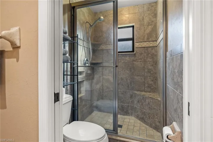 Bathroom with toilet and a shower with shower door