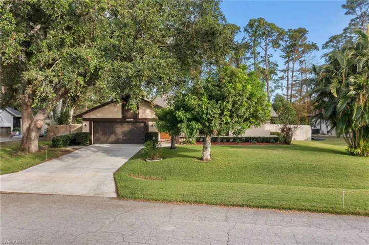 View of front of property with a garage and a front lawn