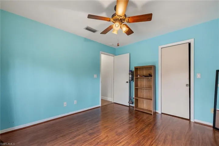 Unfurnished bedroom featuring ceiling fan and dark hardwood / wood-style flooring