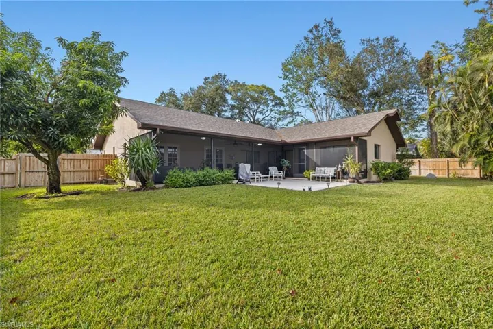 Back of house featuring a lawn, a patio area, and ceiling fan