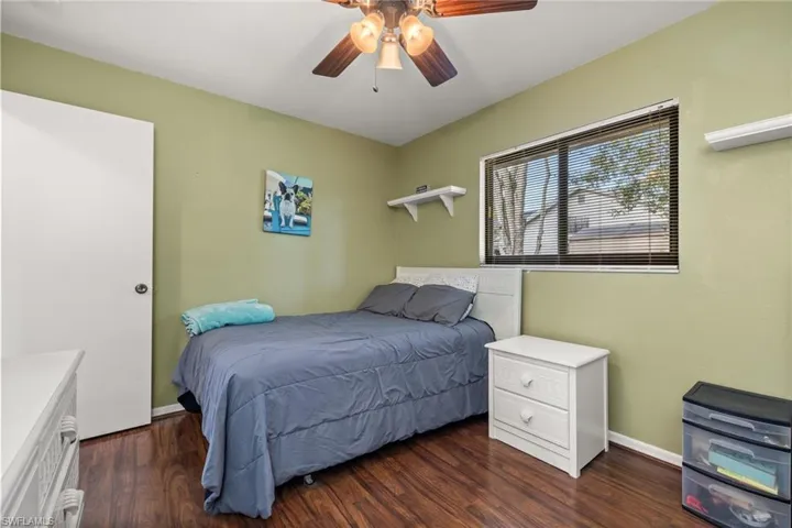 Bedroom with dark hardwood / wood-style flooring and ceiling fan