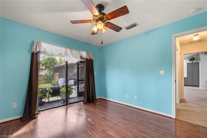 Empty room with ceiling fan and hardwood / wood-style flooring