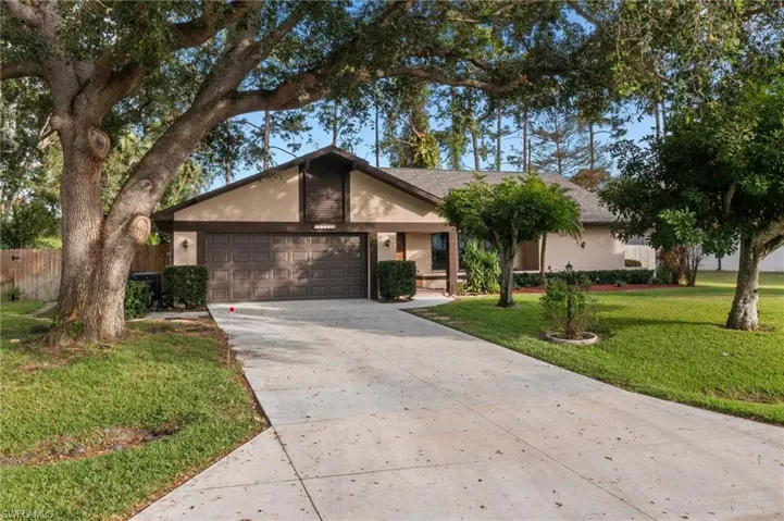 Ranch-style house featuring a front yard and a garage
