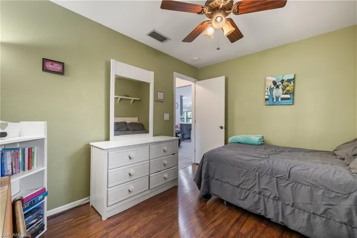 Bedroom with ceiling fan and dark wood-type flooring