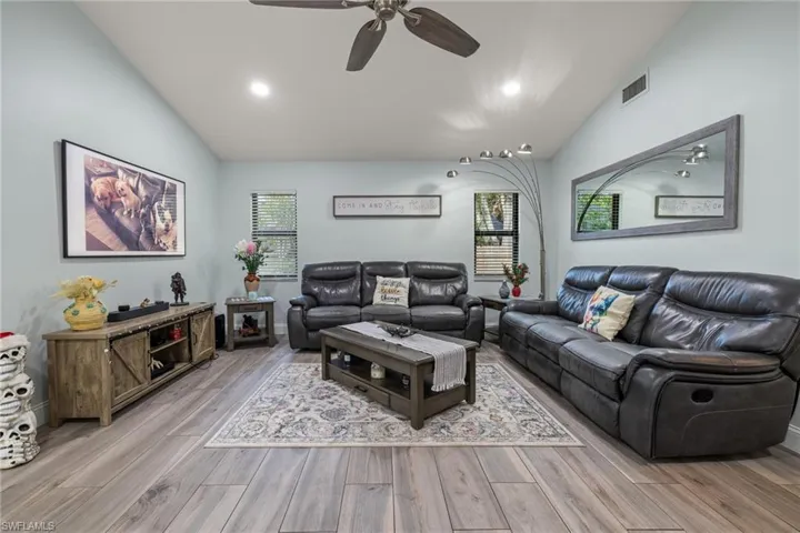 Living room featuring ceiling fan, light hardwood / wood-style floors, and lofted ceiling