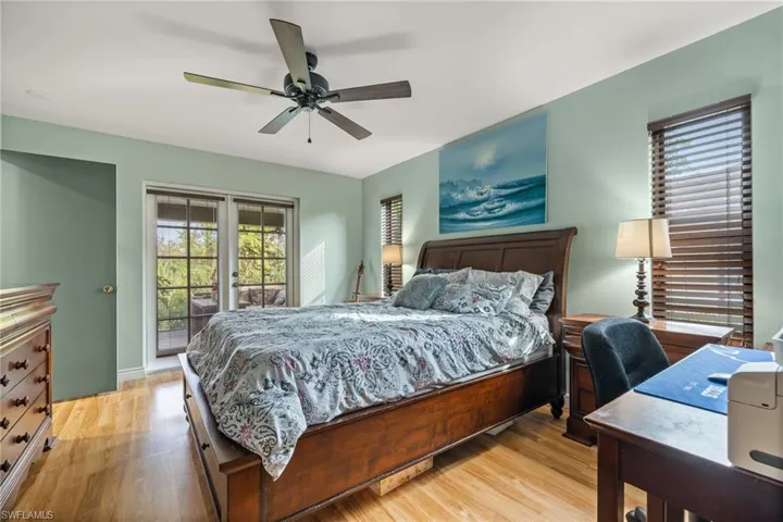 Bedroom featuring access to exterior, light wood-type flooring, and ceiling fan