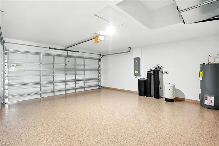 Garage featuring electric water heater and electric panel