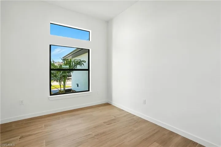 Unfurnished room with baseboards and light wood-type flooring