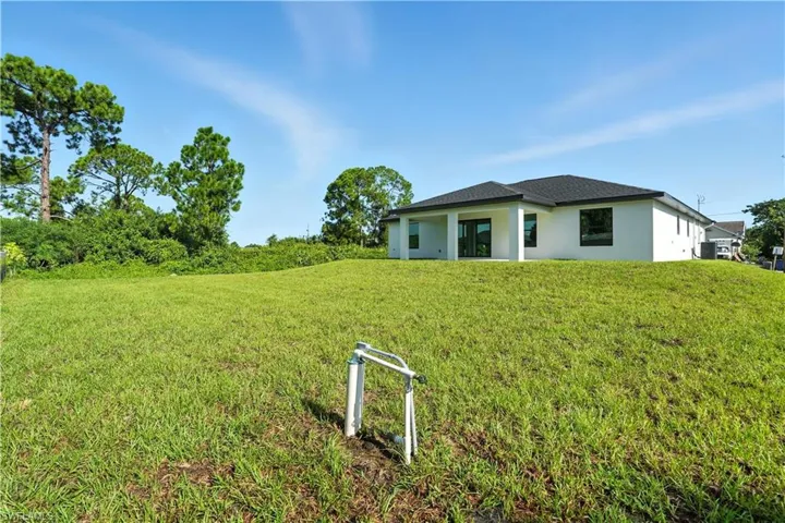 View of front of home with stucco siding and a front yard