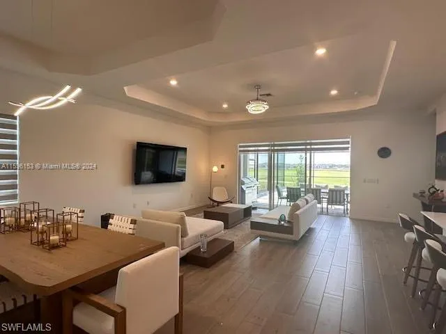 Living room featuring dark wood-type flooring and a tray ceiling