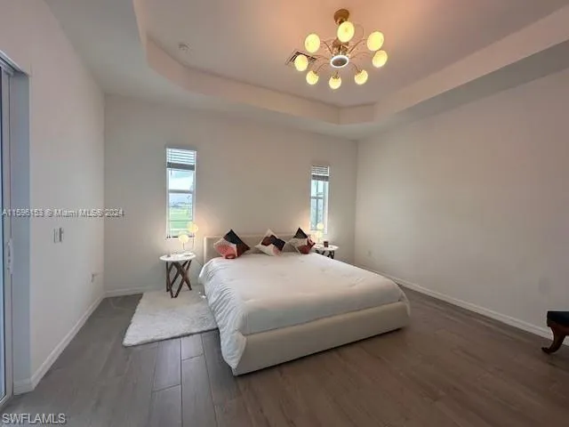 Bedroom with a raised ceiling and hardwood / wood-style floors