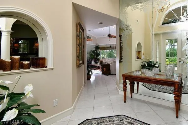 Hallway featuring light tile patterned floors and arched walkways