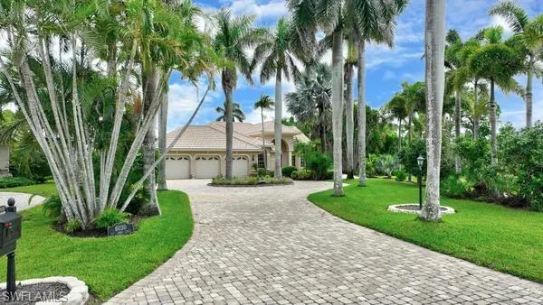 View of front of property with a front lawn, a garage, and decorative driveway