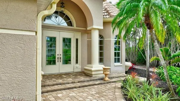 Doorway to property with stucco siding, french doors, and a tile roof
