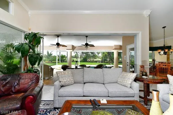 Living room with ornamental molding and a chandelier