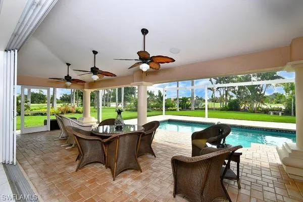 View of patio featuring an outdoor pool, a sunroom, outdoor dining area, a lanai, and ceiling fan