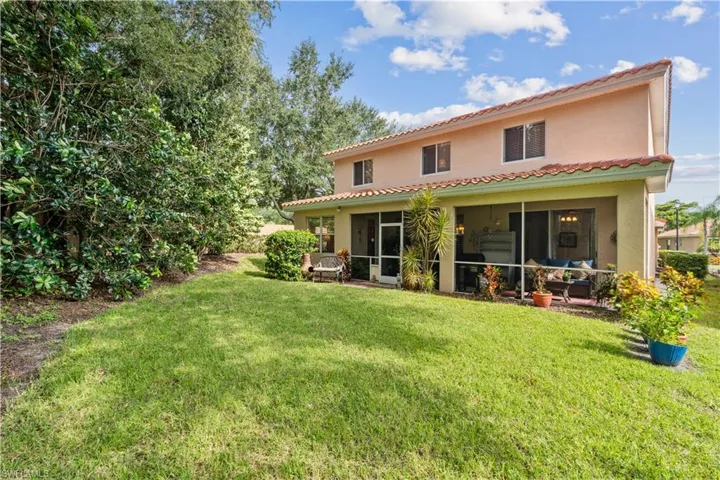 Rear view of property with a yard and a sunroom